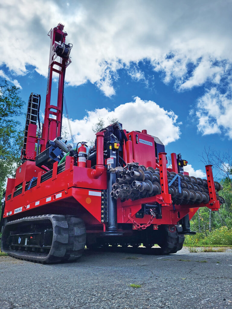 Photo of a red drilling rig parked in a lot.