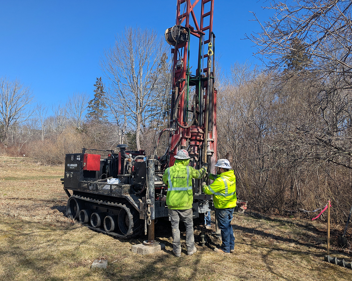 A driller and drilling assistant operating a geotechnical drill rig.